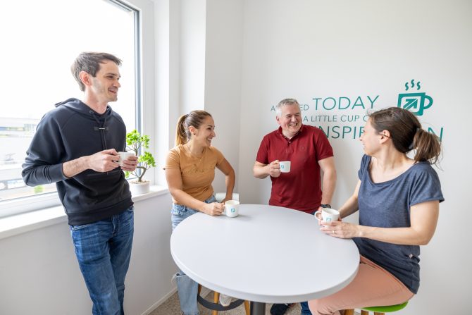 Mitarbeiter:innen beim Kaffee in der Küche