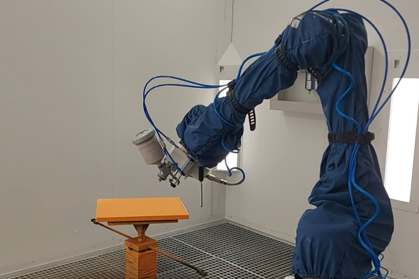 Automatisierung: intelligentes Robotersystem lackiert ein Bauteil automatisch in einer industriellen Lackierkabine
