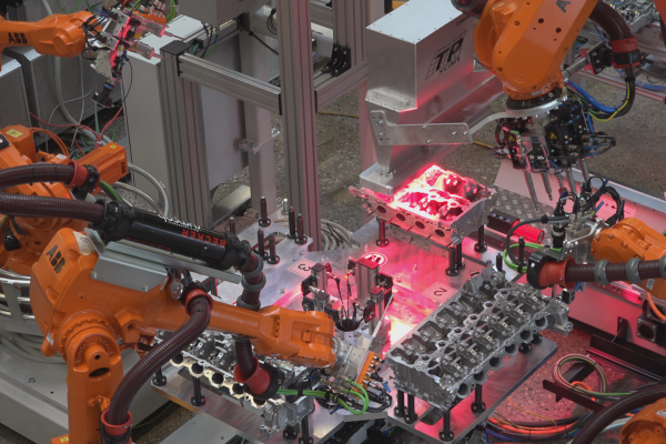 Industrielle Inspektion eines Motorzylinderkopfs mit automatisierter Oberflächenprüfung durch Roboter und 3D-Laserscanner zur Qualitätskontrolle in der Produktion.