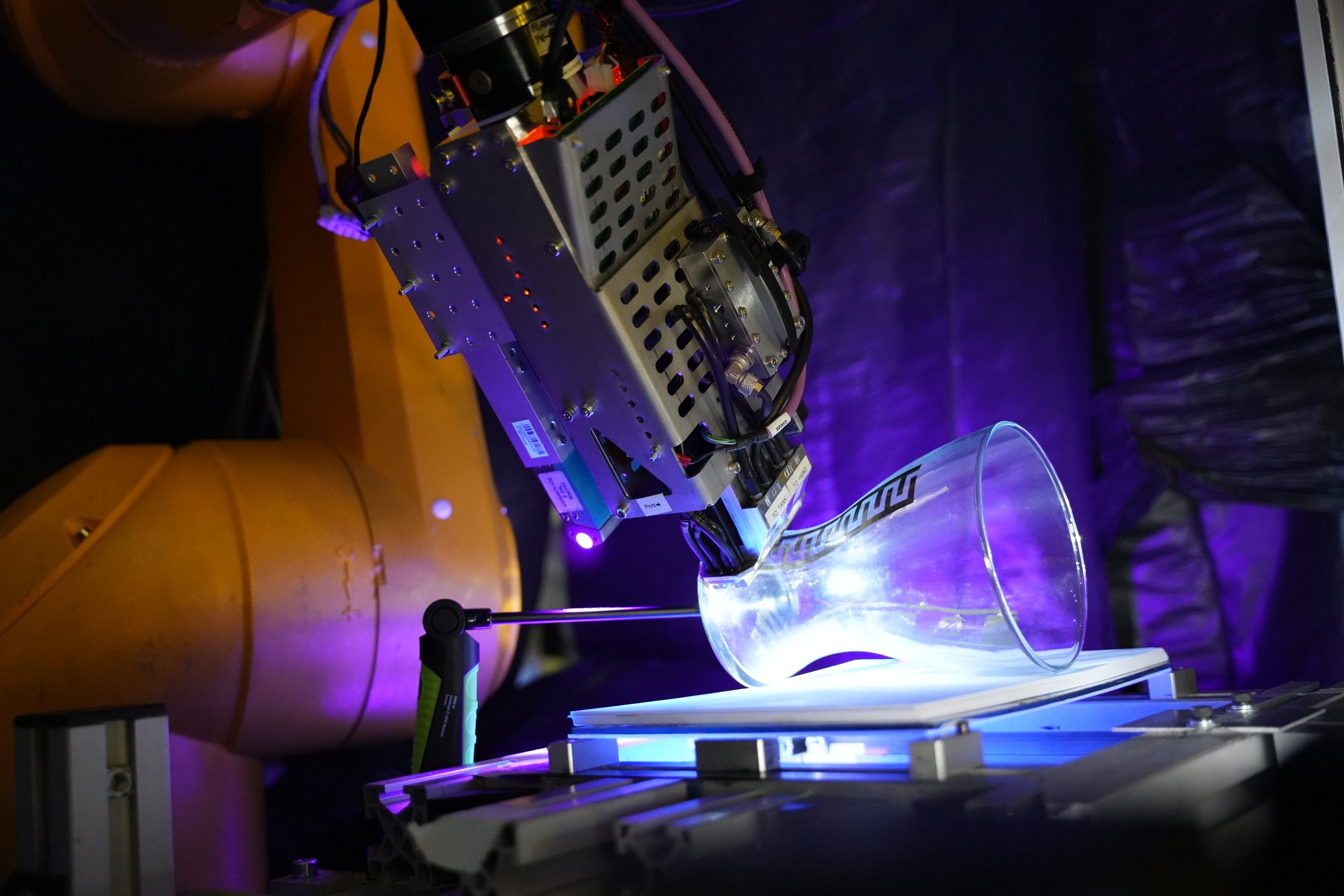 Roboter beim RoboInkjet-Verfahren zur präzisen Bearbeitung oder Beschichtung eines Glasobjekts in der industriellen Fertigung